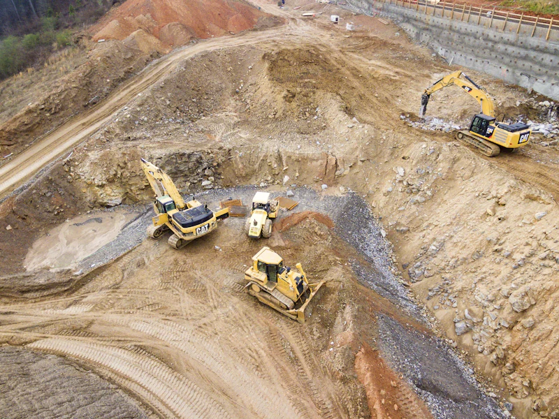 Excavators cutting a foundation into a hillside at an earthworks site