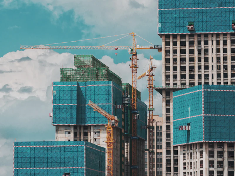 Cluster of high-rise towers under construction with tower cranes at each core