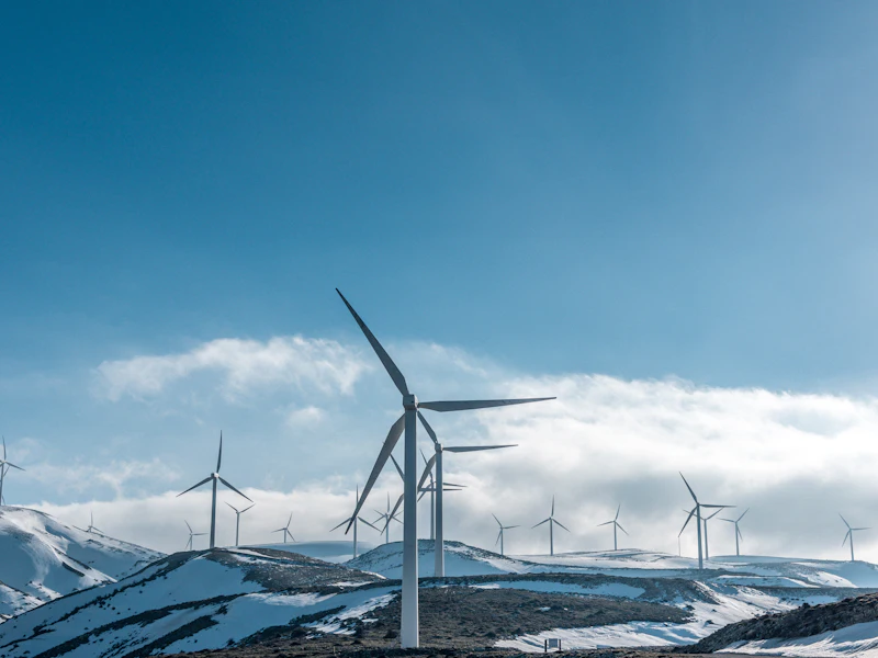Wind turbines on concrete foundations across an open ridge