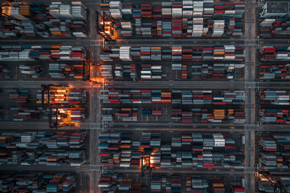 Overhead view of a freight depot with rows of shipping containers and access lanes