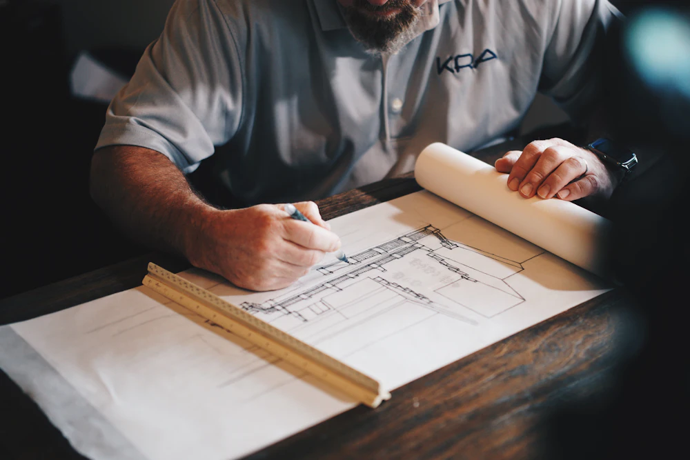 Engineer reviewing a structural drawing at a drafting table